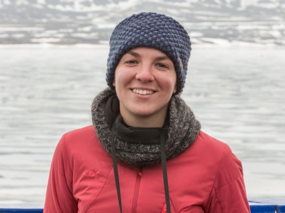 A woman waring a hat in arctic environment, ice in the background